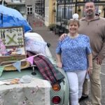 Dolly and Dave Webb stood by their green Figaro beautifully decorated with bunting