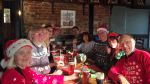 10 owners dressed in Christmas garb smiling at the camera as they have Christmas Dinner together