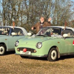 Figaro owners stood by five festively dressed Figaros waving