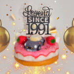 a little nissan figaro on a cake with the words "Legend Since 1991" surrounded by balloons