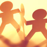 Paper cut outs of people linked together