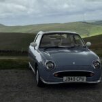 Three Figaros parked with the Peak District behind